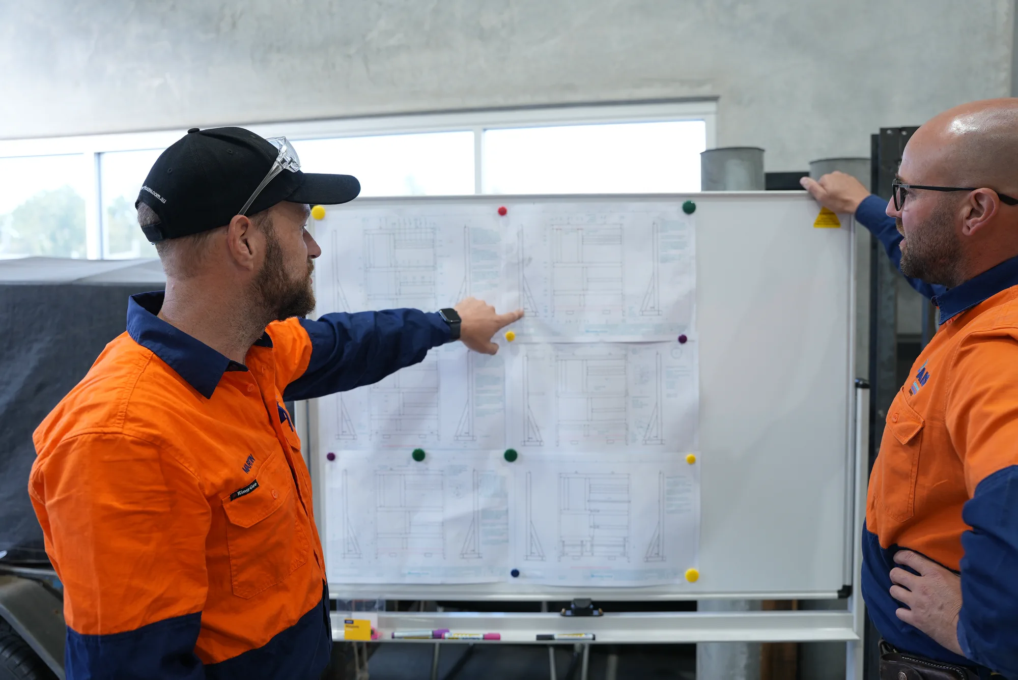 AIS technicians reviewing technical drawings together in the workshop
